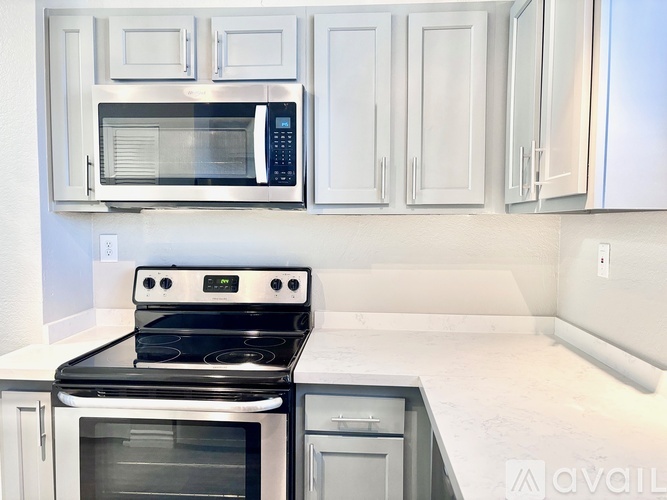 A kitchen with a black stove and white cabinets.