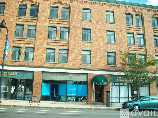 A red brick building with a green awning and a sign that says "Fashion House Men & Women's".