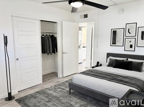 A bedroom with a bed, a ceiling fan, and a wardrobe.