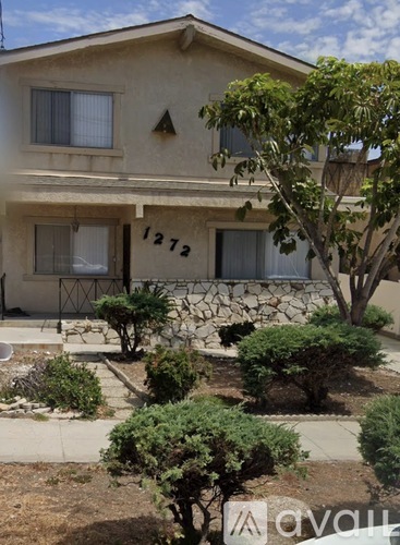 A house numbered 1272 with a tree in front.
