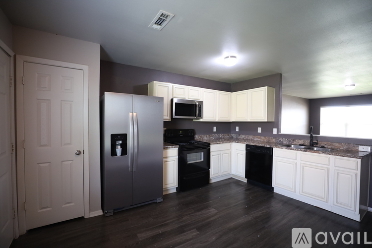 A kitchen with a refrigerator, oven, and microwave.