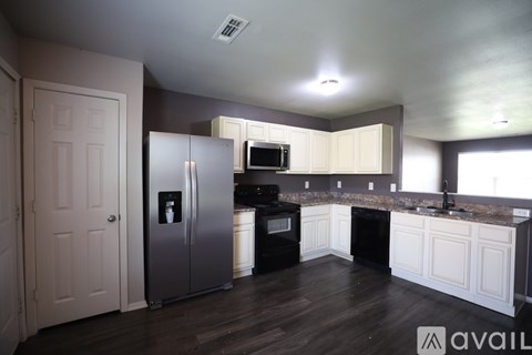 A kitchen with a refrigerator, oven, and microwave.