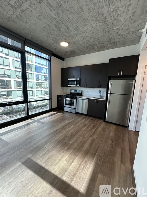 A kitchen with wooden floors and a large window overlooking a cityscape.