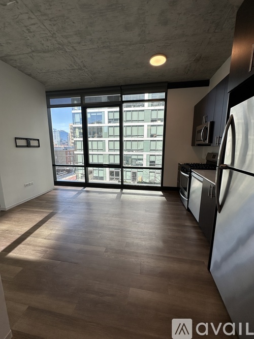 A kitchen with a refrigerator, stove, and oven with a view of the city.