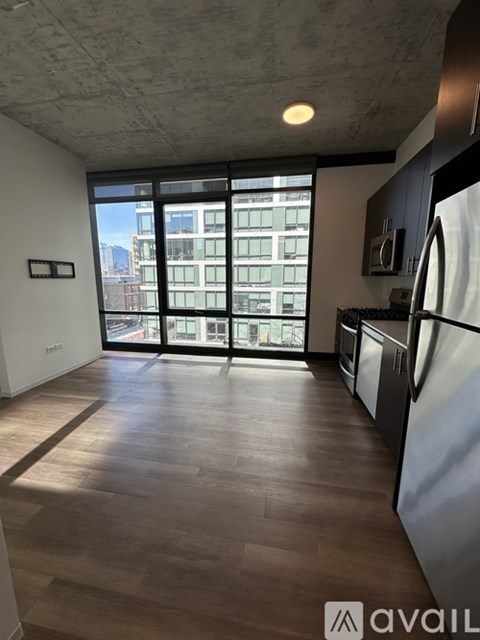 A kitchen with a refrigerator, stove, and oven with a view of the city.