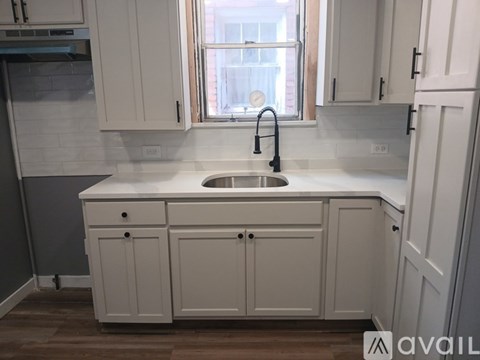 A kitchen with white cabinets and a window.