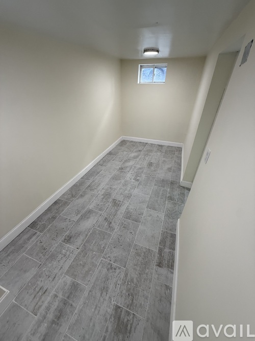 A room with a grey tiled floor and a small window.
