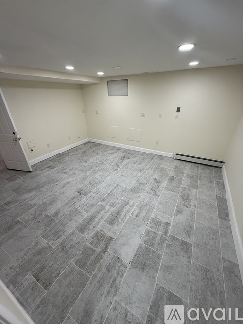 A room with a grey tile floor and white walls.