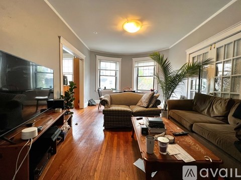 A living room with a wooden floor and a large window.