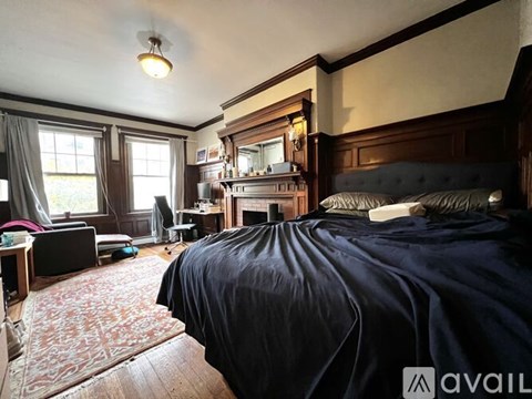 A bedroom with a large bed and a fireplace.
