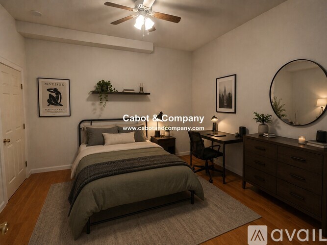 A bedroom with a bed, desk, and chair.