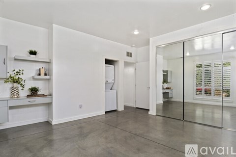 A modern kitchen with white cabinets and a glass door.