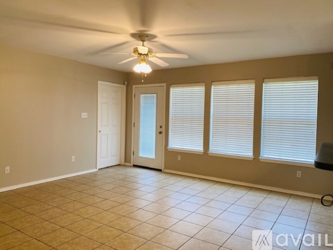 A room with a ceiling fan and tiled flooring.