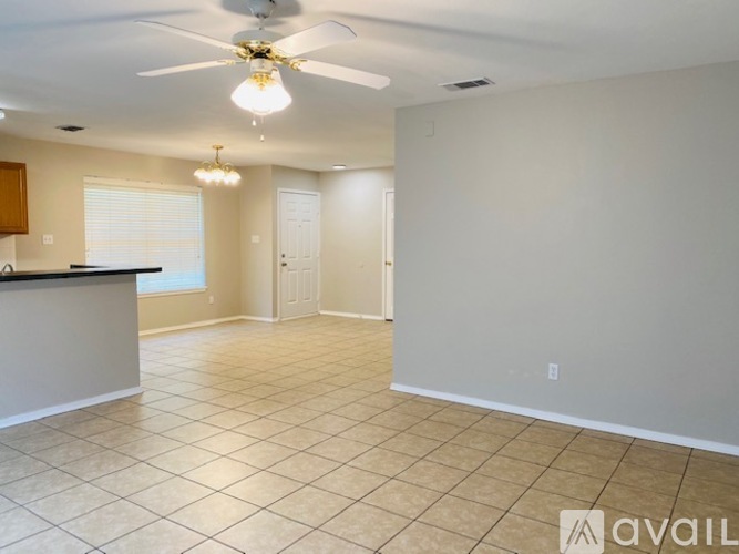 A spacious room with a ceiling fan and tiled flooring.