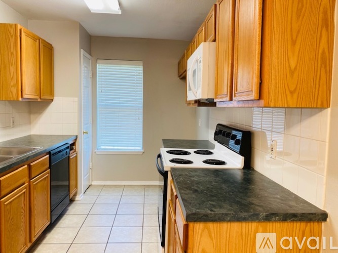 A kitchen with wooden cabinets and a black countertop.