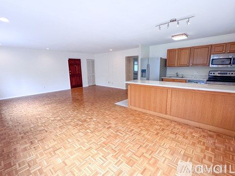 A kitchen with wooden cabinets and a tile floor.