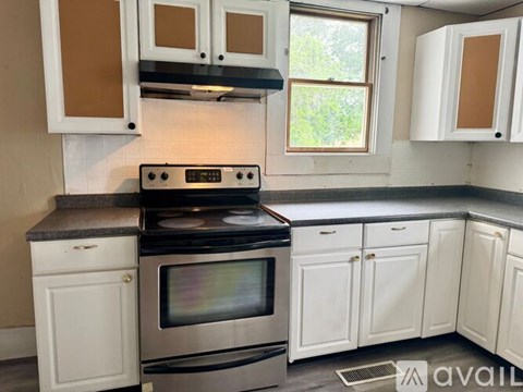 A kitchen with white cabinets and a black stove top oven.