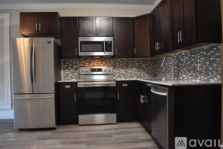 A kitchen with dark wood cabinets and stainless steel appliances.