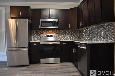 A kitchen with dark wood cabinets and stainless steel appliances.