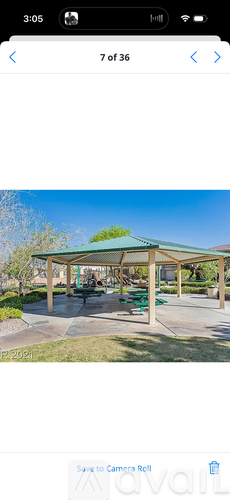A gazebo with a green roof is surrounded by a grassy area.