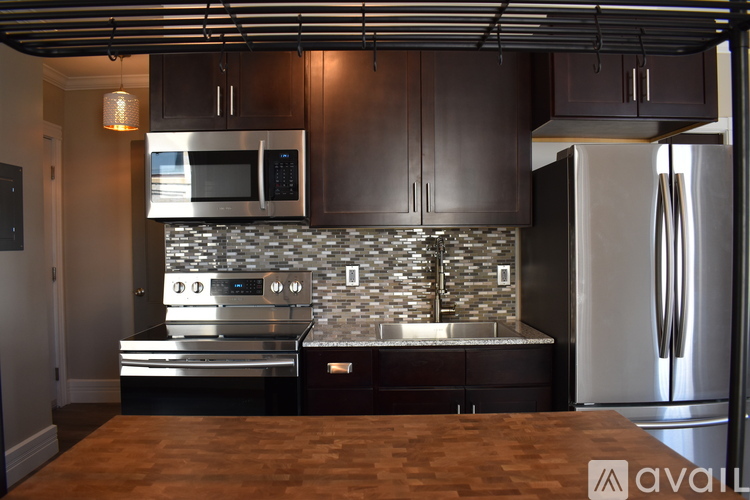 A kitchen with dark wood cabinets and stainless steel appliances.