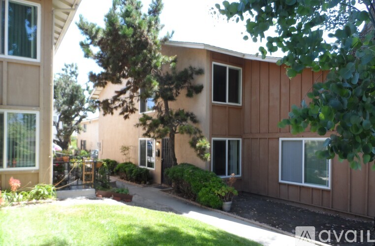 A brown building with a tree in front of it.