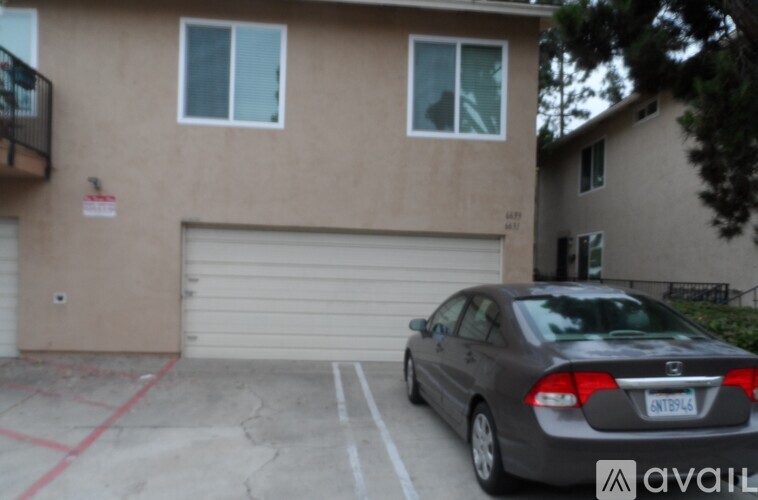 A car is parked in front of a garage door.