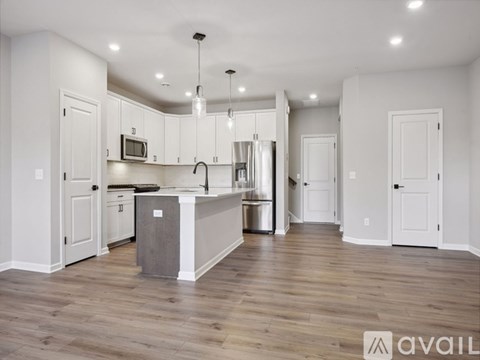 A kitchen with white cabinets and a wooden floor.