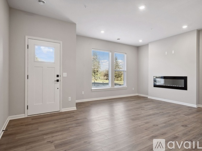 A spacious living room with a fireplace and a door leading to a balcony.
