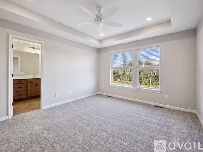 A spacious room with a ceiling fan and large windows.