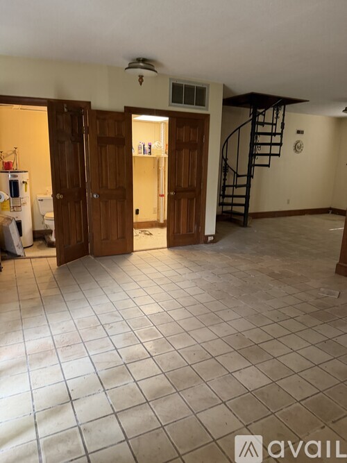 A room with a tiled floor and a staircase.