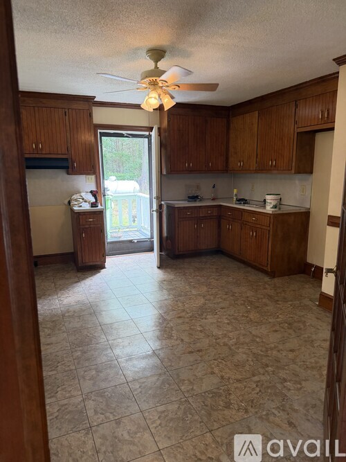 A kitchen with wooden cabinets and a tiled floor.