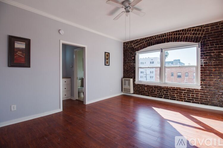 A room with a brick wall and a ceiling fan.