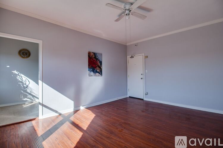 A room with a ceiling fan and a painting on the wall.