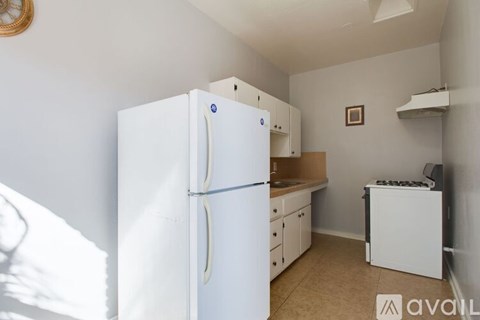 A small kitchen with a white refrigerator and a white dishwasher.