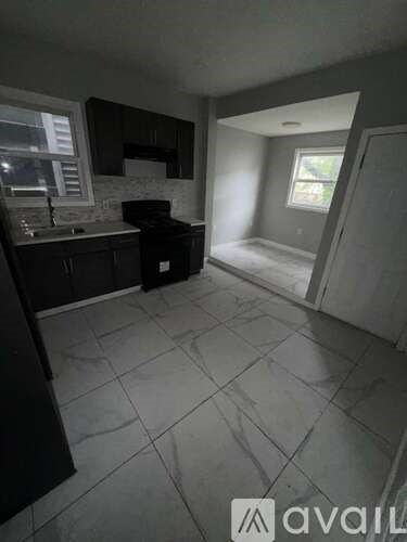 A kitchen with black cabinets and a white countertop.