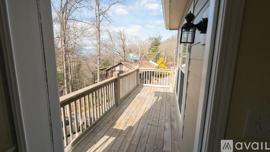 A view from inside a house looking out to a deck with a lantern hanging on the wall.