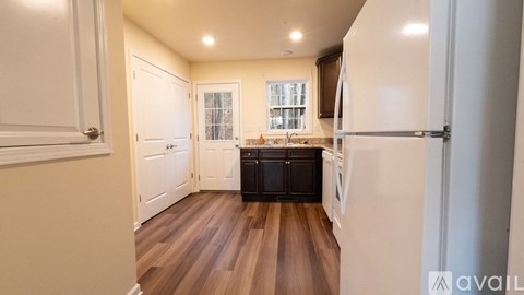 A kitchen with white cabinets and a black fridge.