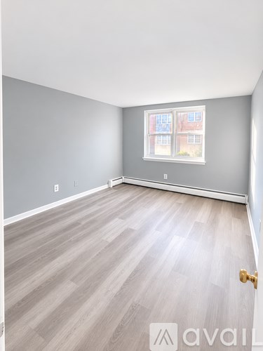 A room with a wooden floor and a window.