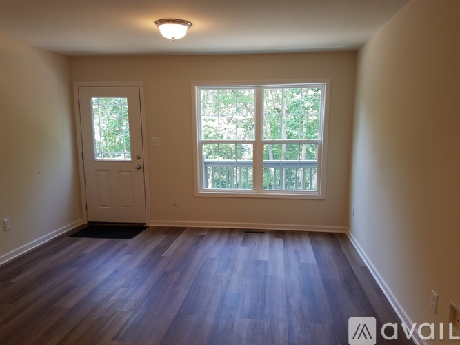 A room with a door and a window with a view of trees.