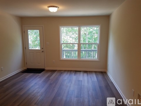A room with a door and a window with a view of trees.