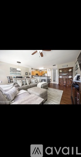 A living room with a couch and a fan.
