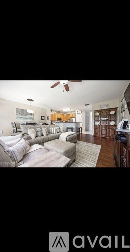 A living room with a couch and a fan.