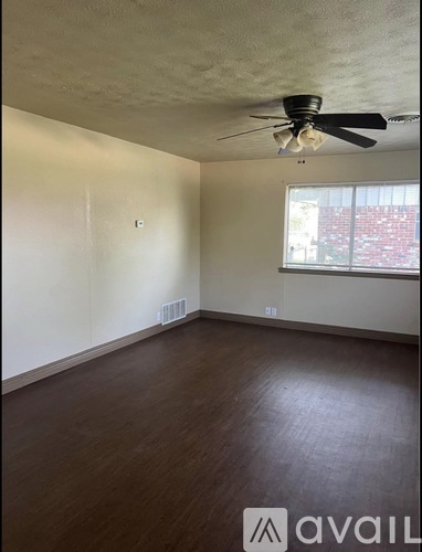 Empty room with a ceiling fan and a window.