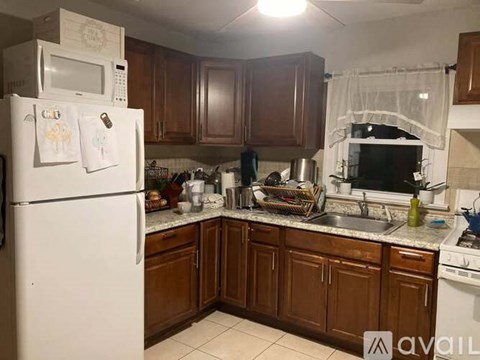 A kitchen with brown cabinets and a white refrigerator.