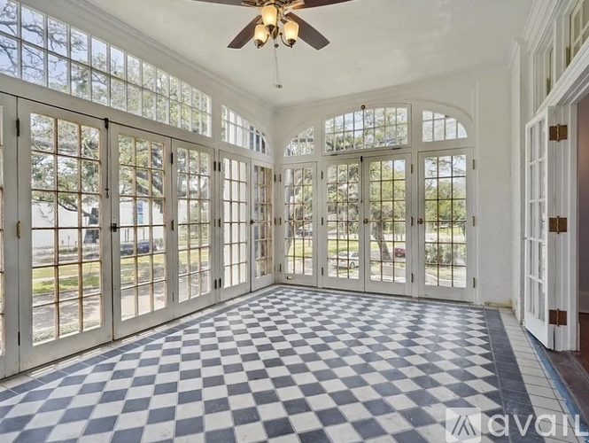 A sunny room with checkered floor and a ceiling fan.
