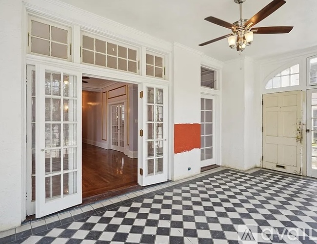 A room with a checkered floor and a ceiling fan.
