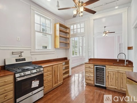 A kitchen with wooden cabinets and a black stove top oven.