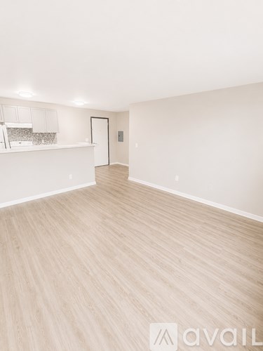 A room with wooden flooring and white walls.