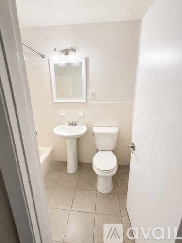 A white toilet and sink in a small bathroom.